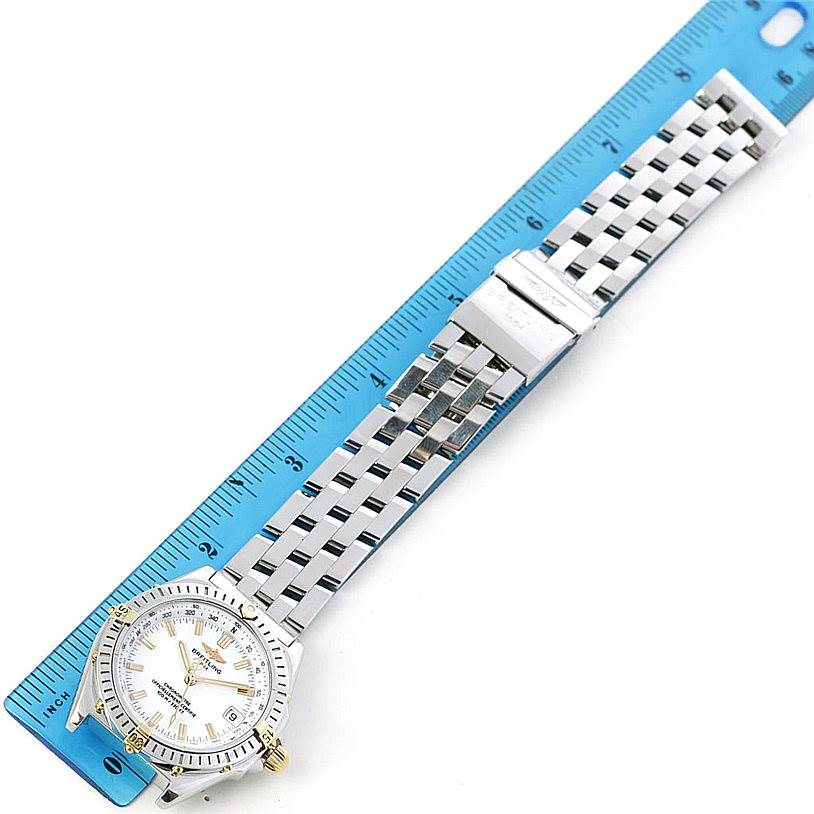 The Breitling Windrider B10350 Men's Steel and Gold (two tone) White Dial B10350 Men's Steel and Gold (two tone) White Dial watch is shown from a top-down angle, displaying the face, bracelet, and clasp next to a ruler for scale.