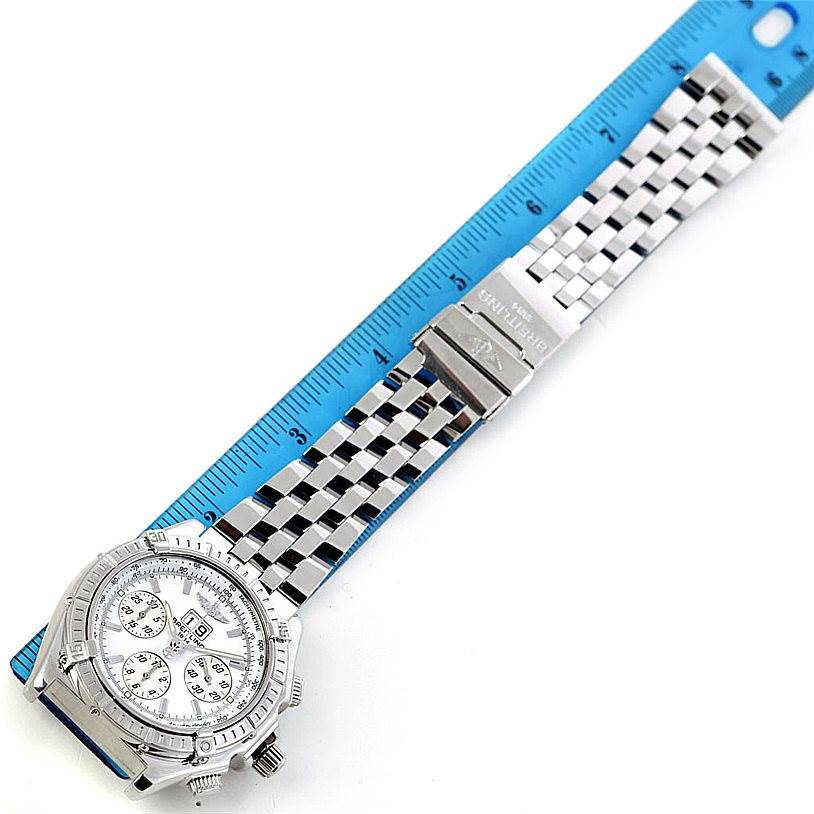 The image shows a Breitling Windrider A44355 Men
s Stainless Steel White Dial A44355 Men
s Stainless Steel White Dial watch at a slight angle, featuring its face, bezel, and stainless steel bracelet laid next to a ruler.