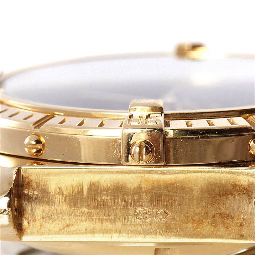 This image shows a side view of the gold bezel and case of a Breitling Windrider K13055 Men
s Yellow Gold Blue Dial K13055 Men
s Yellow Gold Blue Dial watch with detailed screws visible.