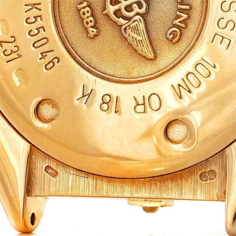The image shows the back case of a Breitling Windrider K55046 Men's Yellow Gold White Dial K55046 Men's Yellow Gold White Dial watch, highlighting its serial number and gold material markings.