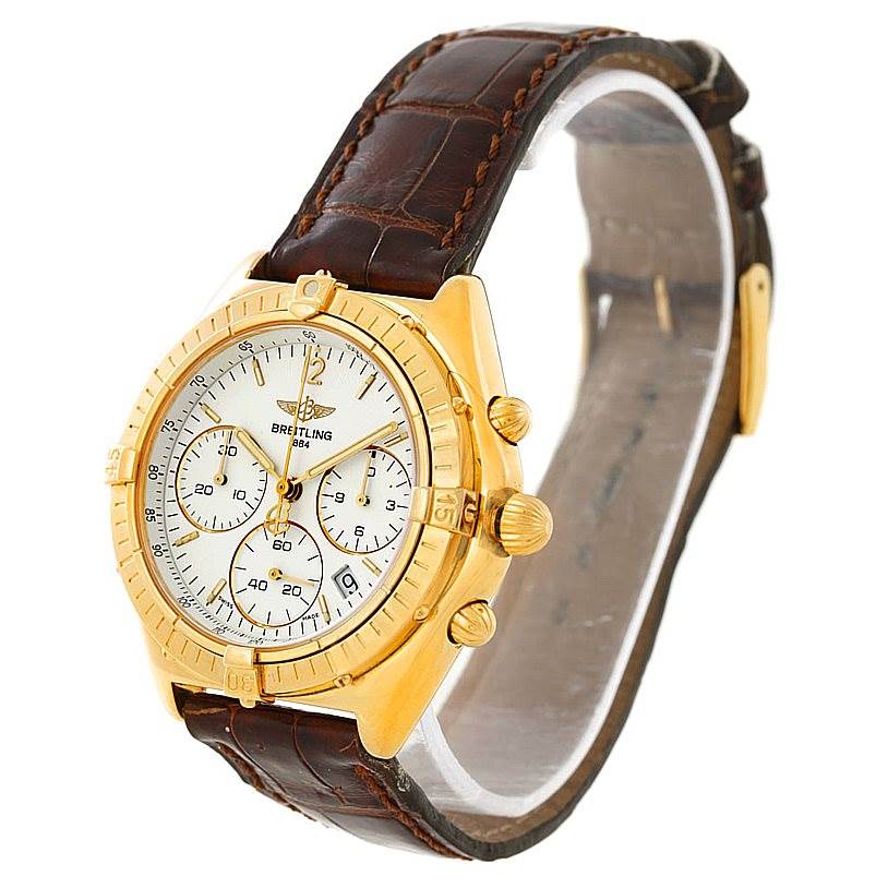 The image shows a Breitling Windrider K55046 Men's Yellow Gold White Dial K55046 Men's Yellow Gold White Dial watch from a side angle, highlighting its gold case, dial, and brown leather strap.