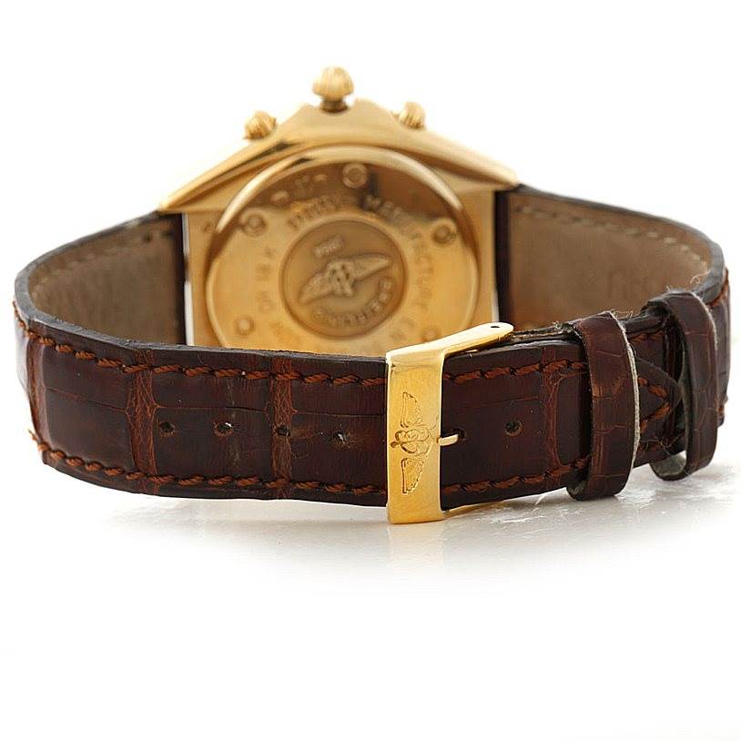 This Breitling Windrider K55046 Men's Yellow Gold White Dial K55046 Men's Yellow Gold White Dial watch is shown from the back, highlighting its case back and leather strap with a gold buckle.