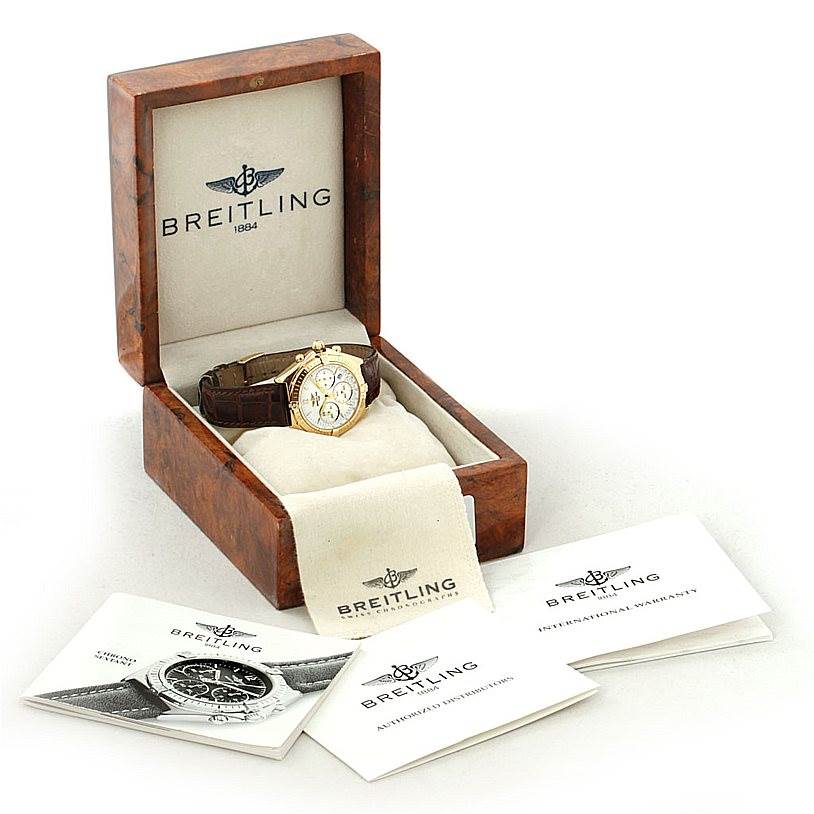 The image shows a Breitling Windrider K55046 Men's Yellow Gold White Dial K55046 Men's Yellow Gold White Dial watch in an open wooden box with documents and fabric accessories.