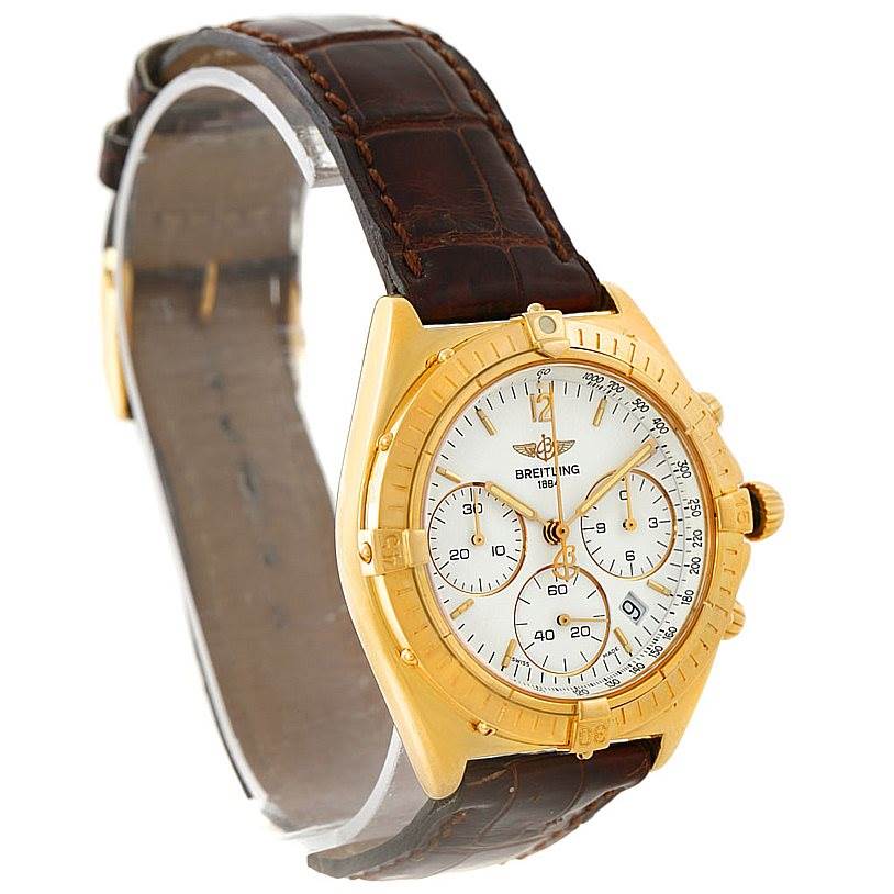 This Breitling Windrider K55046 Men's Yellow Gold White Dial K55046 Men's Yellow Gold White Dial watch is shown from a three-quarter angle displaying the dial, bezel, crown, and brown leather strap.