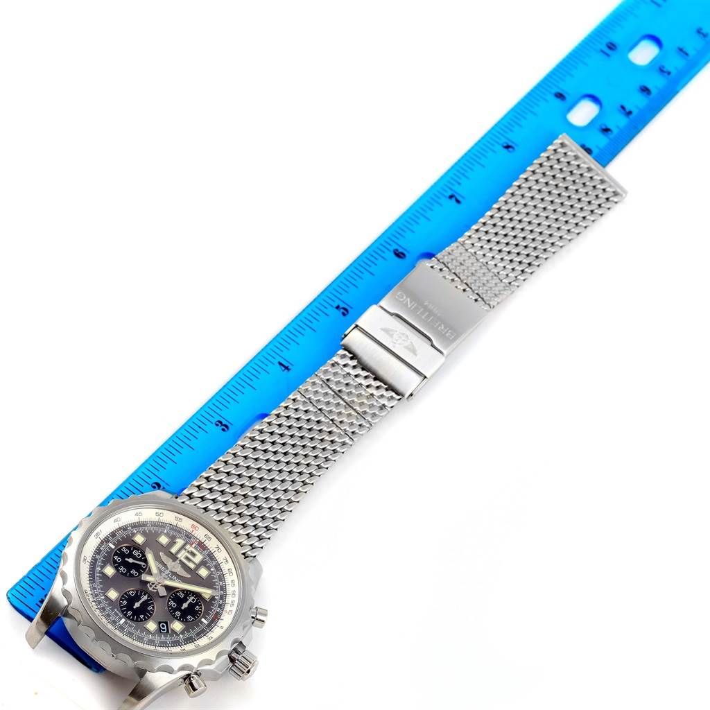 The image shows a top-view angle of a Breitling Professional Series A23360 Men's Stainless Steel Grey Dial A23360 Men's Stainless Steel Grey Dial watch with a mesh band alongside a blue ruler for measurement.
