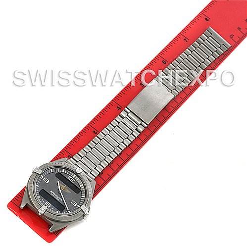 This image shows a Professional Series Breitling watch laid flat with a metal band beside a red ruler.