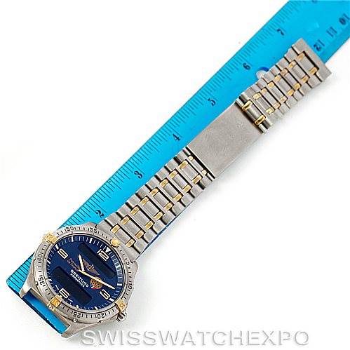 The Breitling Professional Series F56062 Men's Titanium Blue Dial F56062 Men's Titanium Blue Dial watch is shown in a top-down view, revealing its face, bezel, bracelet, and clasp alongside a blue ruler.
