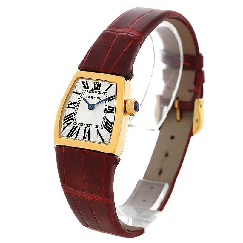 This is a La Dona model by Cartier, shown at an angle highlighting its gold case, white dial with Roman numerals, and red leather strap.