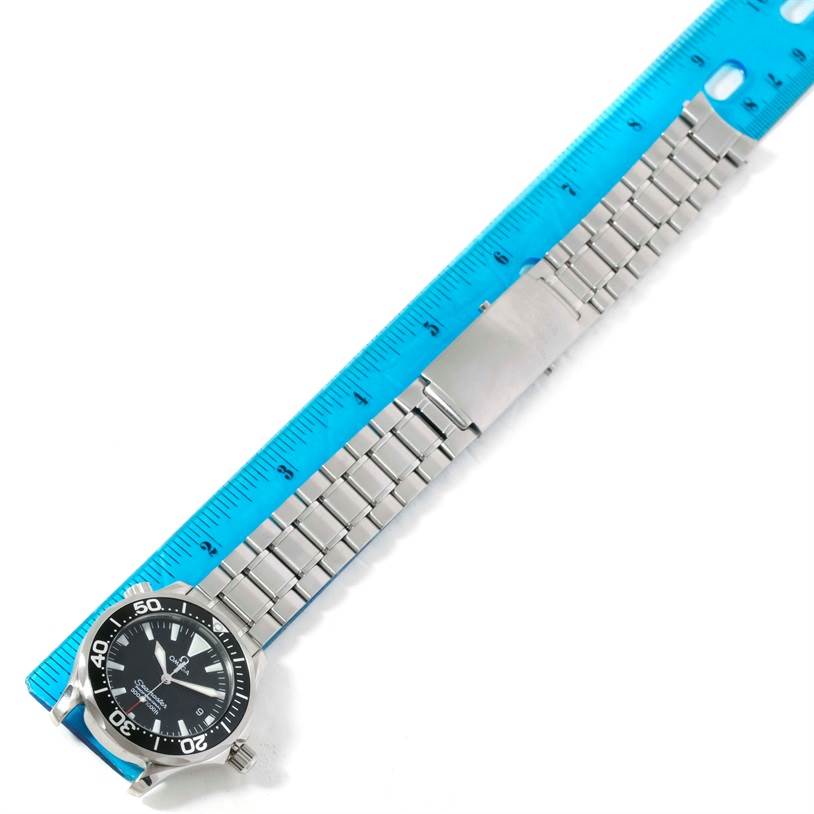 The image shows an Omega Seamaster 2262.50.00 Men
s Stainless Steel Black Dial 2262.50.00 Men
s Stainless Steel Black Dial wristwatch laid next to a blue ruler, highlighting its stainless steel bracelet and clasp.