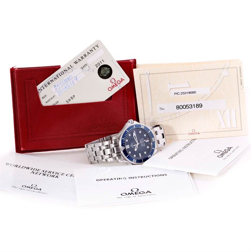 The image shows an Omega Seamaster 2531.80.00 Men
s Stainless Steel Blue Dial 2531.80.00 Men
s Stainless Steel Blue Dial watch with its warranty card, service documents, and manual, all displayed at an angle.