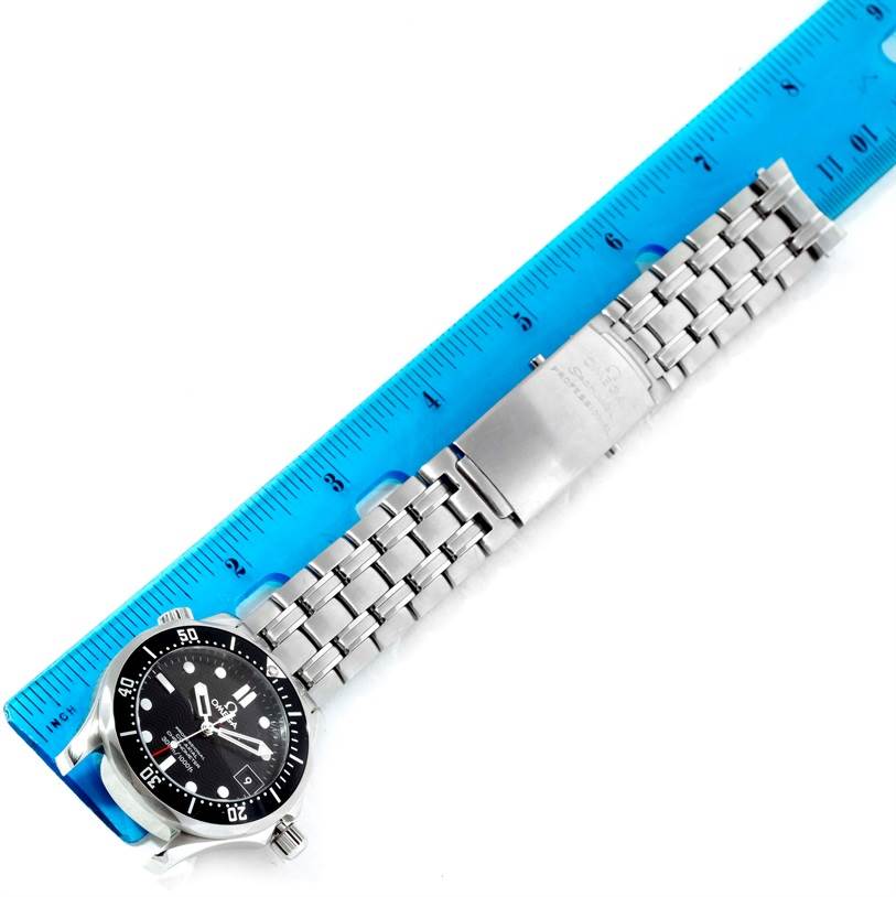 The image shows an Omega Seamaster 212.30.36.20.01.001 Stainless Steel Black Dial 212.30.36.20.01.001 Stainless Steel Black Dial watch face and stainless steel bracelet laid next to a blue ruler.