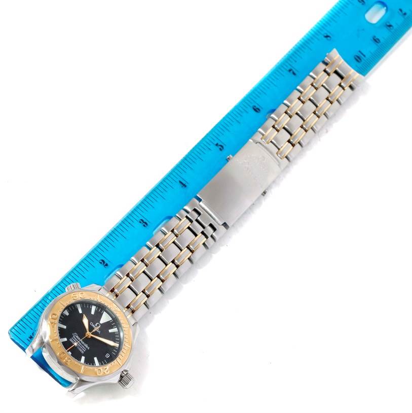 The image shows an Omega Seamaster Men's Stainless Steel Black Dial Men's Stainless Steel Black Dial watch laid flat next to a ruler, displaying its face, bezel, case, and bracelet.