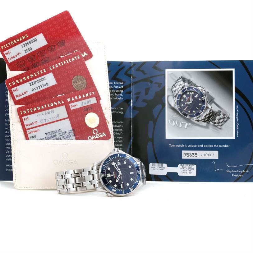 The image shows an Omega Seamaster 2226.80.00 Men
s Stainless Steel Blue Dial 2226.80.00 Men
s Stainless Steel Blue Dial watch, warranty cards, and documentation, arranged at an angle showcasing the face and bracelet.