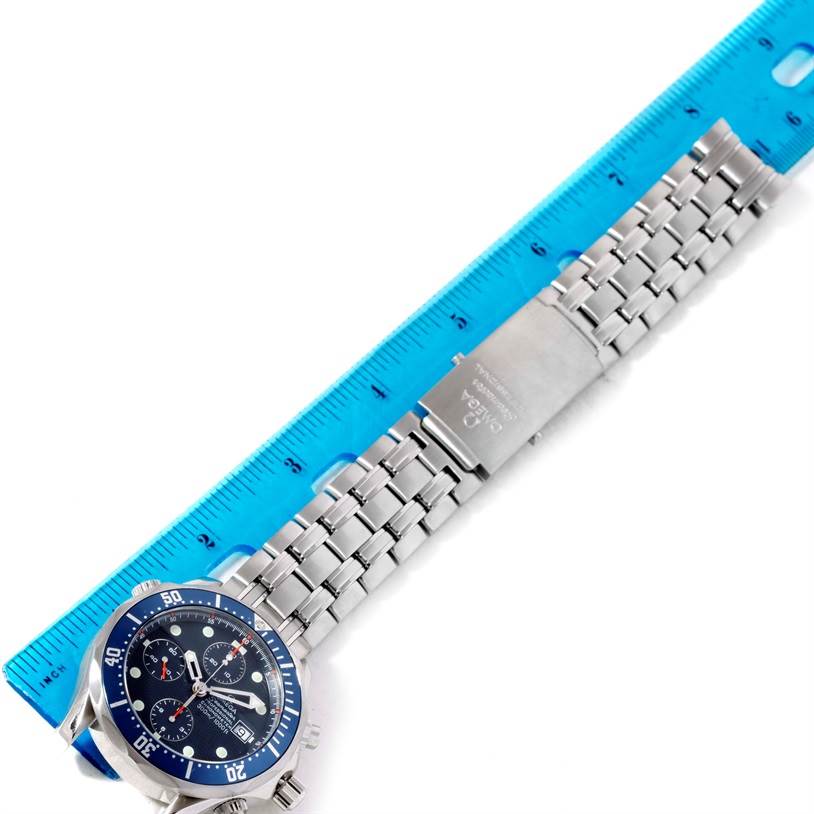 The image shows an Omega Seamaster 2599.80.00 Men
s Stainless Steel Blue Dial 2599.80.00 Men
s Stainless Steel Blue Dial watch laid flat with its bracelet and clasp extended along a blue ruler.