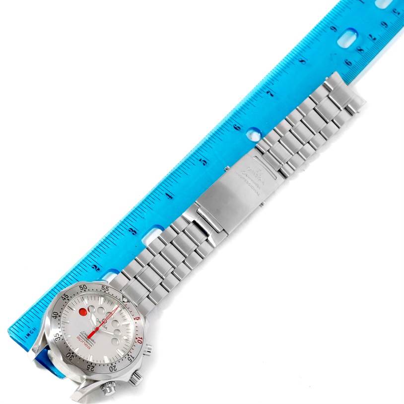 The image shows an Omega Seamaster 2595.30.00 Men
s Stainless Steel Silver Dial 2595.30.00 Men
s Stainless Steel Silver Dial watch laid flat next to a blue ruler, highlighting the strap and face.