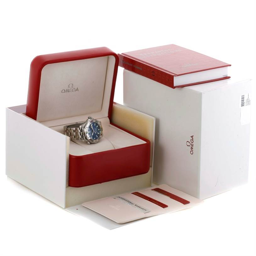 The Omega Seamaster 2053.80.00 Men
s Stainless Steel Blue Dial 2053.80.00 Men
s Stainless Steel Blue Dial watch is displayed at an angle inside an open watch box, with accompanying manuals and a card outside.