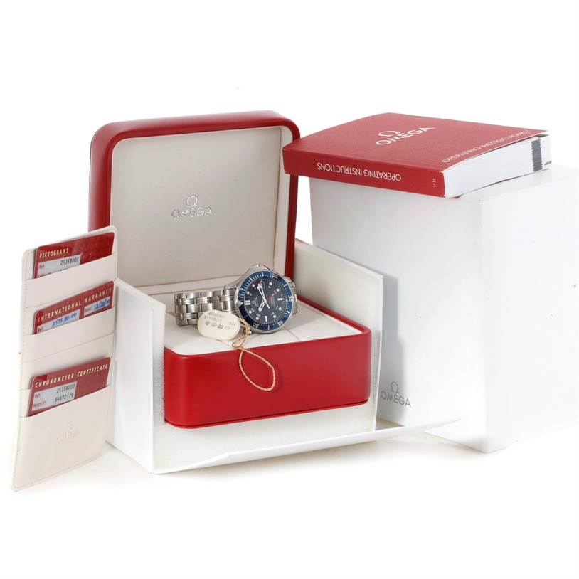 The image shows an Omega Seamaster 2535.80.00 Men
s Stainless Steel Blue Dial 2535.80.00 Men
s Stainless Steel Blue Dial watch, its red box, instruction manual, and warranty cards from a front angle.