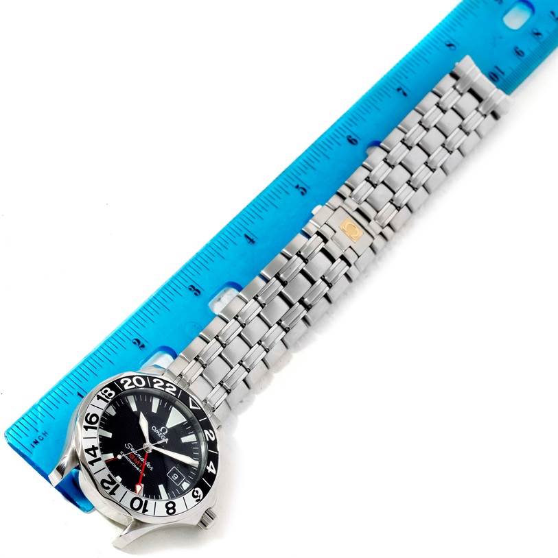 The image shows an Omega Seamaster 2534.50.00 Men's Stainless Steel Black Dial 2534.50.00 Men's Stainless Steel Black Dial watch flat against a blue ruler, displaying the watch face and metal bracelet.