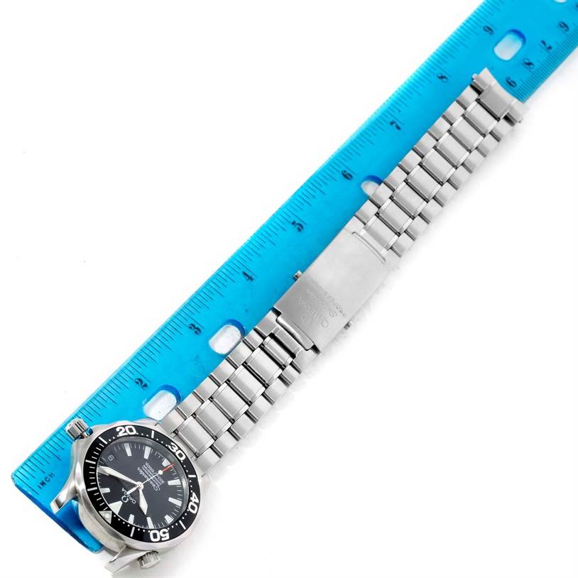 This image shows an Omega Seamaster 2252.50.00 Men
s Stainless Steel Black Dial 2252.50.00 Men
s Stainless Steel Black Dial watch laid flat with a blue ruler for scale, featuring its face and metal bracelet.