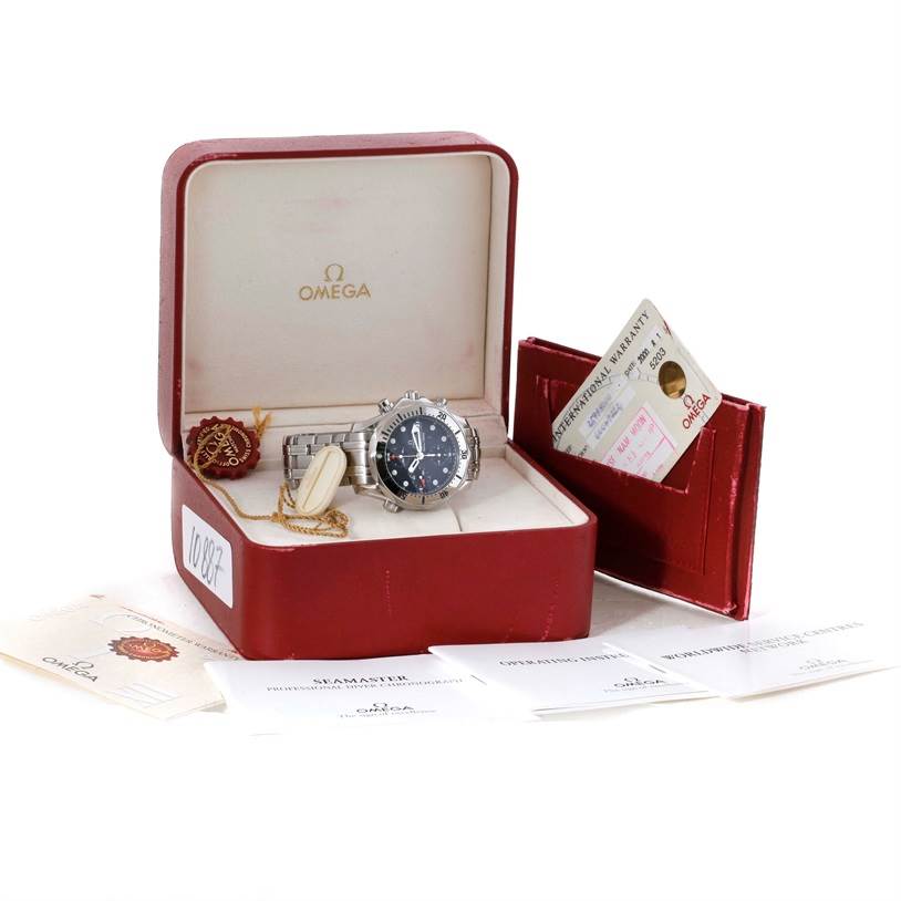 The Omega Seamaster 2598.80.00 Men
s Stainless Steel Blue Dial 2598.80.00 Men
s Stainless Steel Blue Dial watch is shown inside its open box with warranty cards and documents displayed around it.