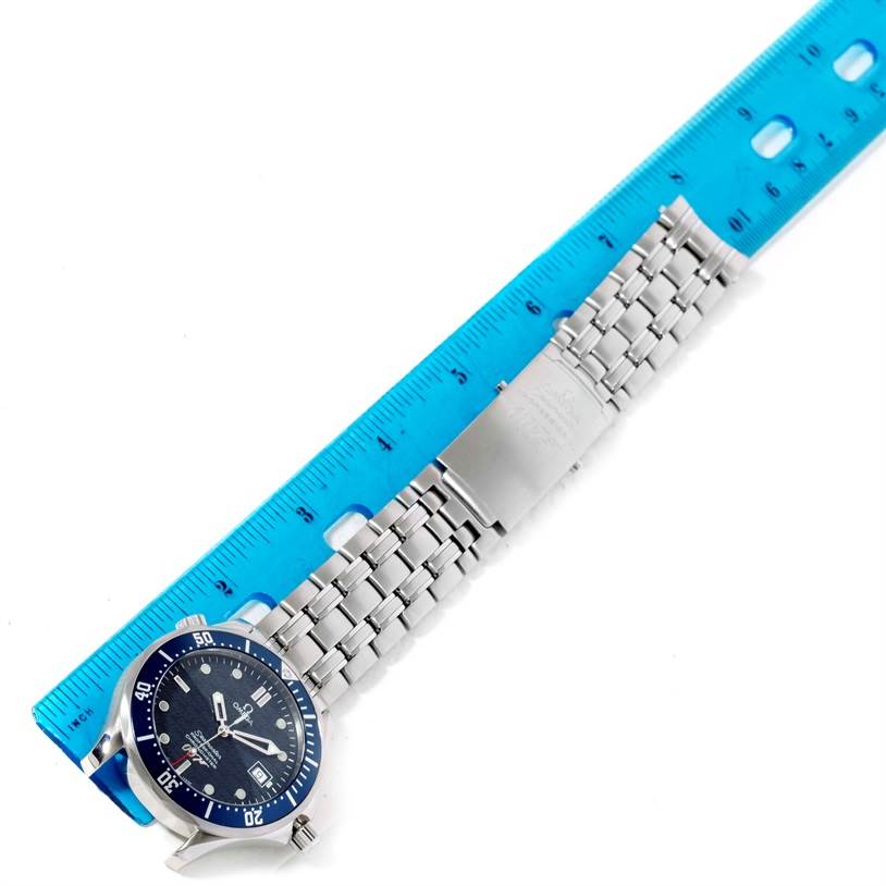 The image shows an Omega Seamaster 2537.80.00 Men
s Stainless Steel Blue Dial 2537.80.00 Men
s Stainless Steel Blue Dial watch placed alongside a blue ruler, displaying its face, bezel, and metal bracelet.