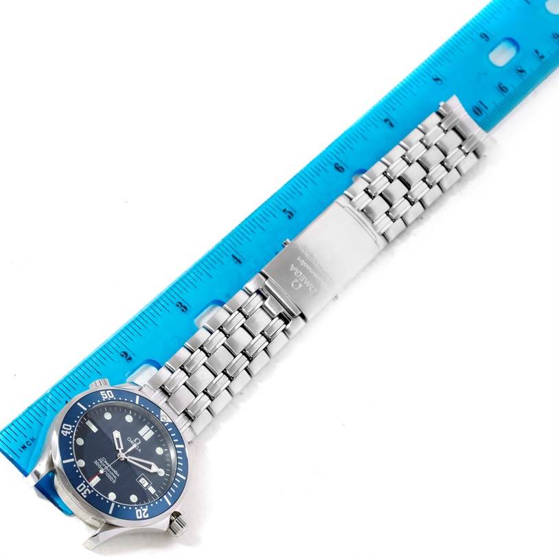 The image shows an Omega Seamaster 2541.80.00 Men
s Stainless Steel Blue Dial 2541.80.00 Men
s Stainless Steel Blue Dial watch laid flat with a blue ruler, displaying its face, bezel, clasp, and stainless steel bracelet.