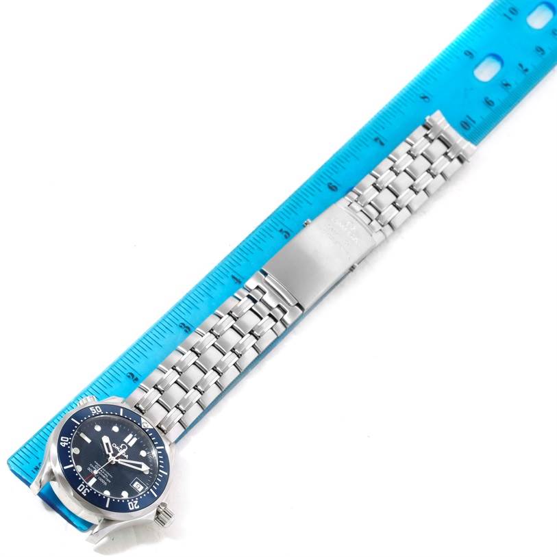 The image shows an Omega Seamaster 2222.80.00 Men
s Stainless Steel Blue Dial 2222.80.00 Men
s Stainless Steel Blue Dial watch laid flat, with a focus on the face, bezel, and metal bracelet, alongside a blue ruler.