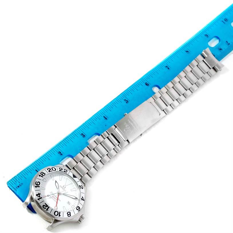 The Omega Seamaster 2538.20.00 Men
s Stainless Steel White Dial 2538.20.00 Men
s Stainless Steel White Dial watch is shown from a top-down angle, displaying the face, bezel, and bracelet lying next to a ruler for scale.