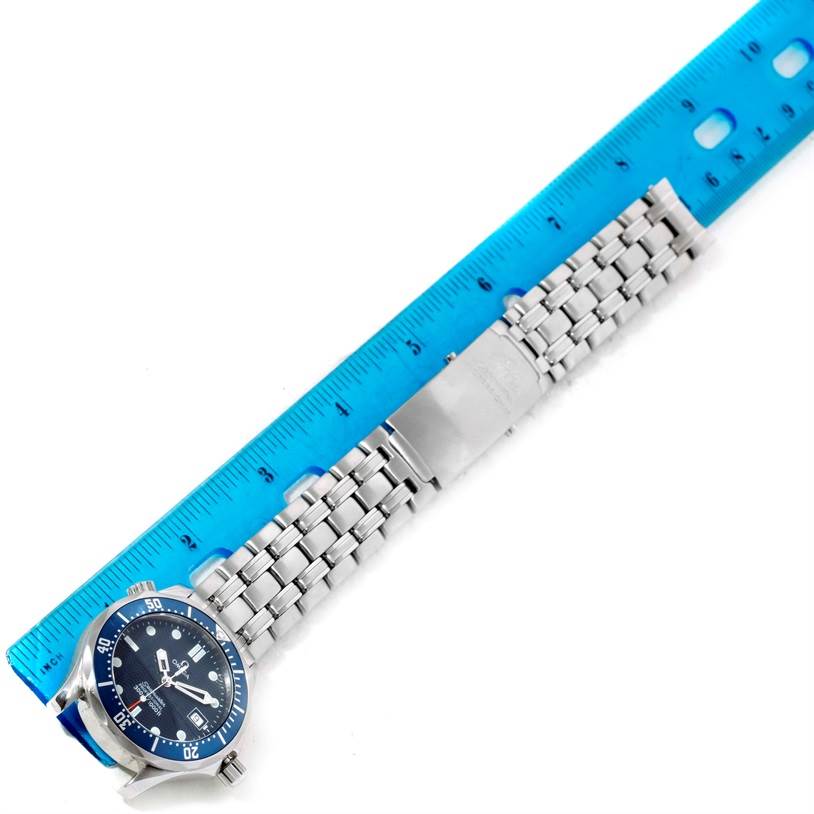 The image shows the Omega Seamaster 2561.80.00 Men
s Stainless Steel Blue Dial 2561.80.00 Men
s Stainless Steel Blue Dial watch horizontally, focusing on its face and metal bracelet next to a blue ruler for scale.