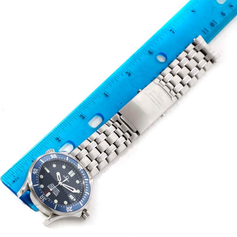 The image shows a side view of an Omega Seamaster 2531.80.00 Men
s Stainless Steel Blue Dial 2531.80.00 Men
s Stainless Steel Blue Dial watch with its stainless steel bracelet, measured against a blue ruler.