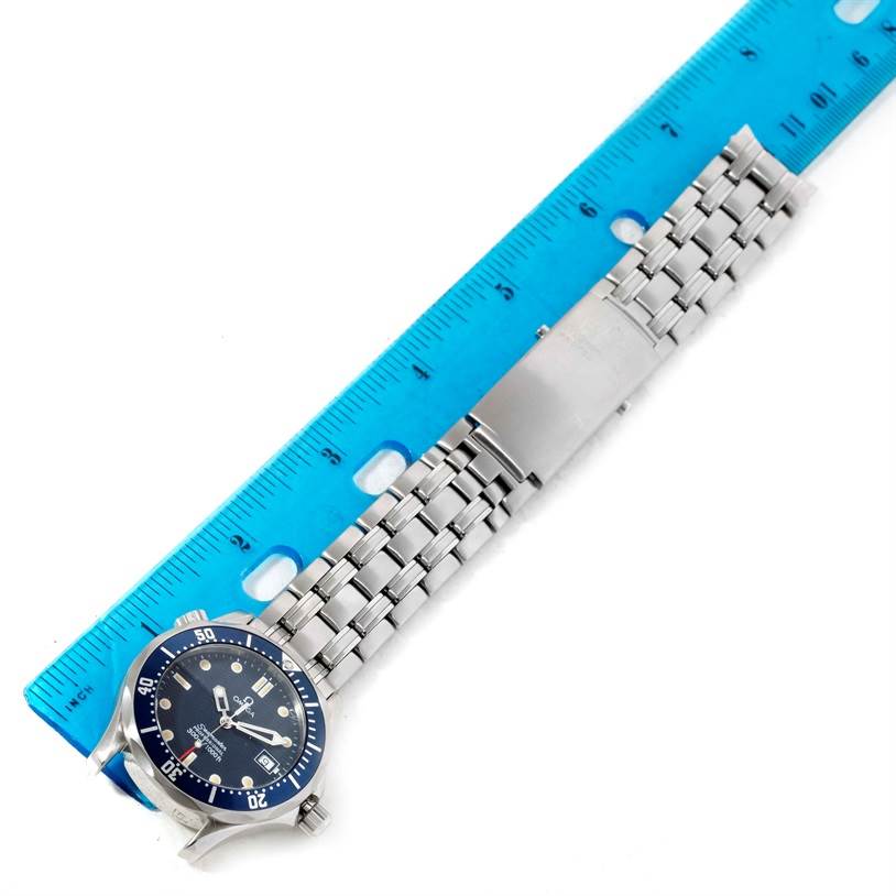 The image shows a top-down view of an Omega Seamaster 2561.80.00 Men
s Stainless Steel Blue Dial 2561.80.00 Men
s Stainless Steel Blue Dial
s face and bracelet beside a blue ruler for scale.