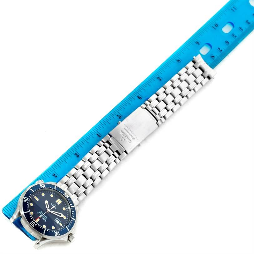 The image shows an Omega Seamaster 2541.80.00 Men
s Stainless Steel Blue Dial 2541.80.00 Men
s Stainless Steel Blue Dial watch laid flat against a blue ruler, displaying the face and entire metal bracelet with clasp.