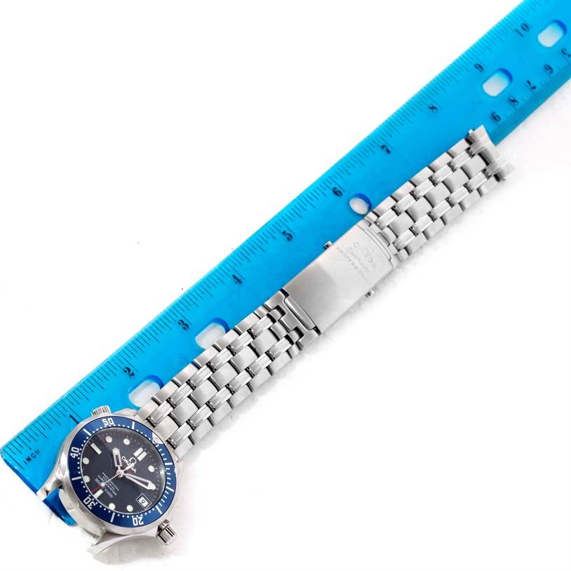 The Omega Seamaster 2222.80.00 Men
s Stainless Steel Blue Dial 2222.80.00 Men
s Stainless Steel Blue Dial watch is shown fully extended horizontally next to a blue ruler, displaying its dial and metal bracelet.