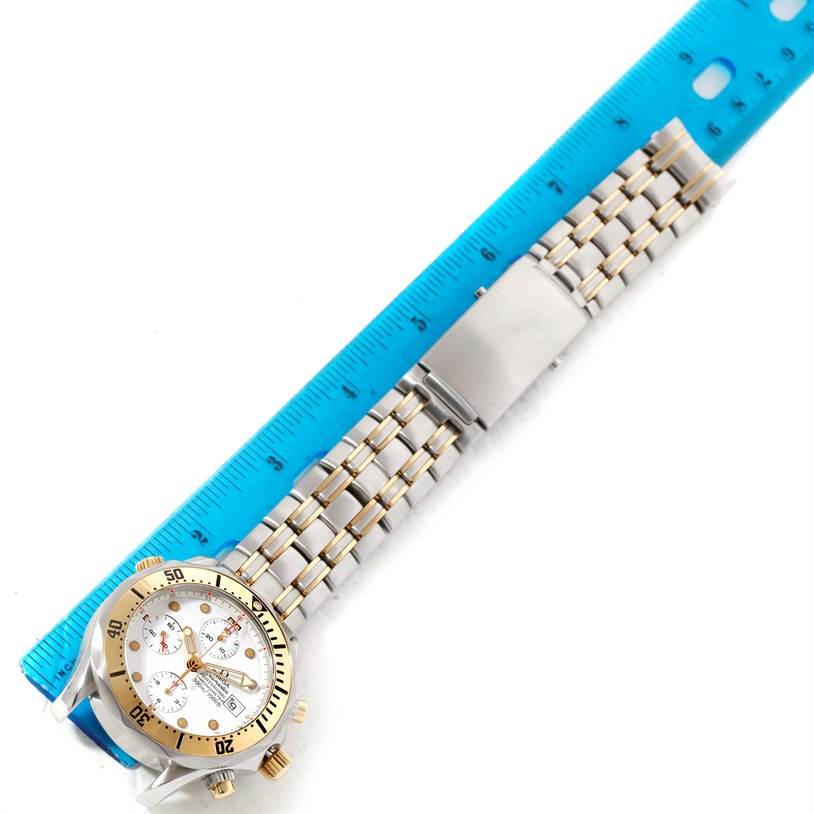 The image shows a top view of an Omega Seamaster 2398.20.00 Men's Steel and Gold (two tone) White Dial 2398.20.00 Men's Steel and Gold (two tone) White Dial watch with a metallic bracelet, alongside a blue ruler for measurement.