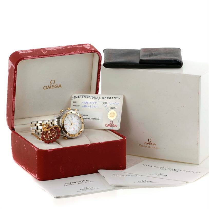 The Omega Seamaster 2398.20.00 Men's Steel and Gold (two tone) White Dial 2398.20.00 Men's Steel and Gold (two tone) White Dial watch is displayed alongside its warranty card, tags, and manuals in a red box, all viewed from a front angle.
