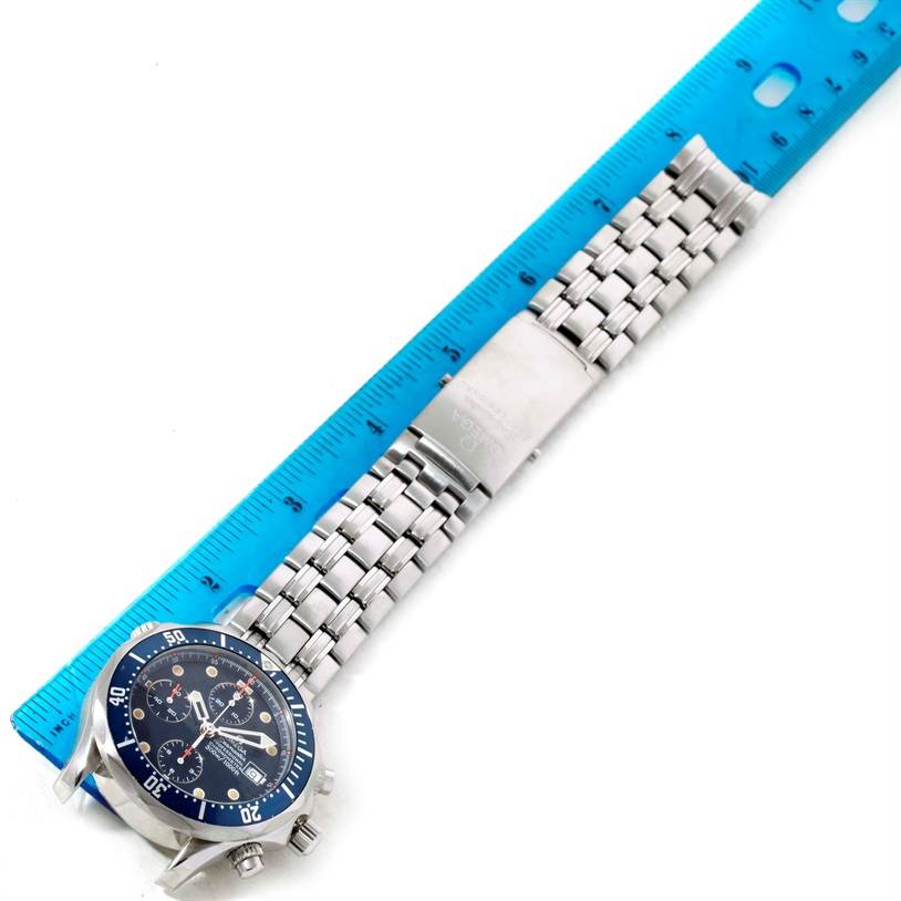 The Omega Seamaster 2599.80.00 Men
s Stainless Steel Blue Dial 2599.80.00 Men
s Stainless Steel Blue Dial watch is shown from above, displaying the face, bracelet, and clasp next to a ruler.