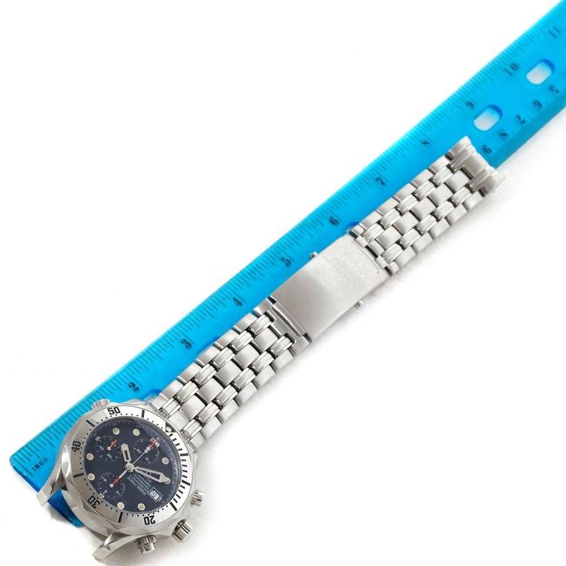 The Omega Seamaster 2598.80.00 Men
s Stainless Steel Blue Dial 2598.80.00 Men
s Stainless Steel Blue Dial watch is shown from the top view, displaying its face and metal bracelet alongside a blue ruler for scale.