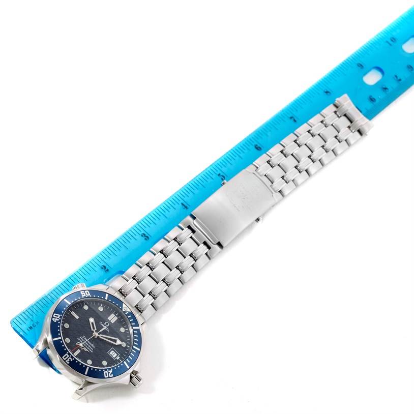 The image shows an Omega Seamaster 2537.80.00 Men
s Stainless Steel Blue Dial 2537.80.00 Men
s Stainless Steel Blue Dial watch lying flat next to a blue ruler, highlighting the bracelet and clasp.