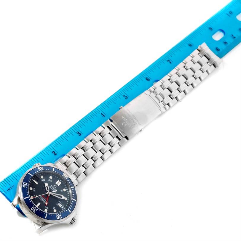 The image shows an Omega Seamaster 2535.80.00 Men
s Stainless Steel Blue Dial 2535.80.00 Men
s Stainless Steel Blue Dial watch laid flat with the bracelet extended, measured alongside a blue ruler.