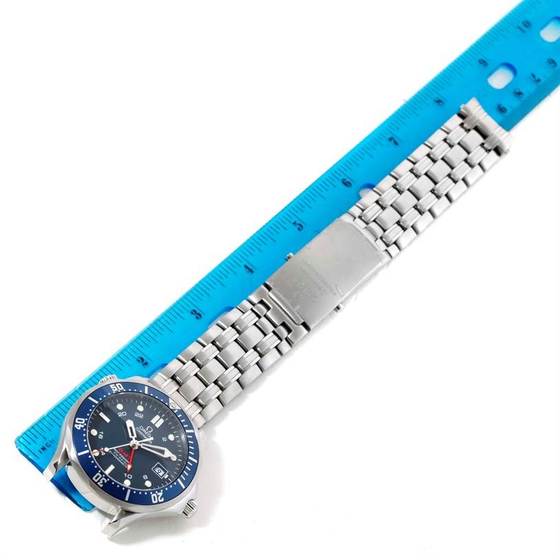 The Omega Seamaster 2535.80.00 Men
s Stainless Steel Blue Dial 2535.80.00 Men
s Stainless Steel Blue Dial watch is shown from a top-down angle with its face and metal bracelet visible, next to a blue ruler for size reference.