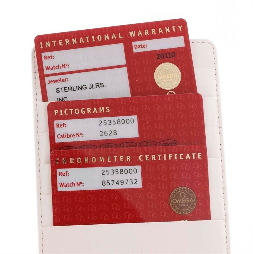 The image shows warranty cards and certificates for an Omega Seamaster 2535.80.00 Men
s Stainless Steel Blue Dial 2535.80.00 Men
s Stainless Steel Blue Dial watch, viewed from above.