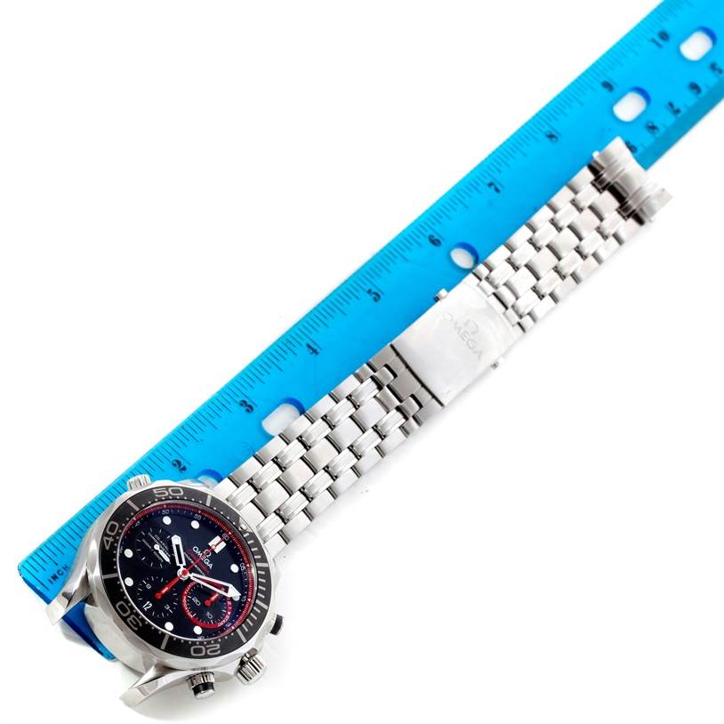 The image shows an Omega Seamaster 212.32.44.50.01.001 Men
s Stainless Steel Black Dial 212.32.44.50.01.001 Men
s Stainless Steel Black Dial watch laid flat with its stainless steel bracelet and clasp beside a blue ruler.