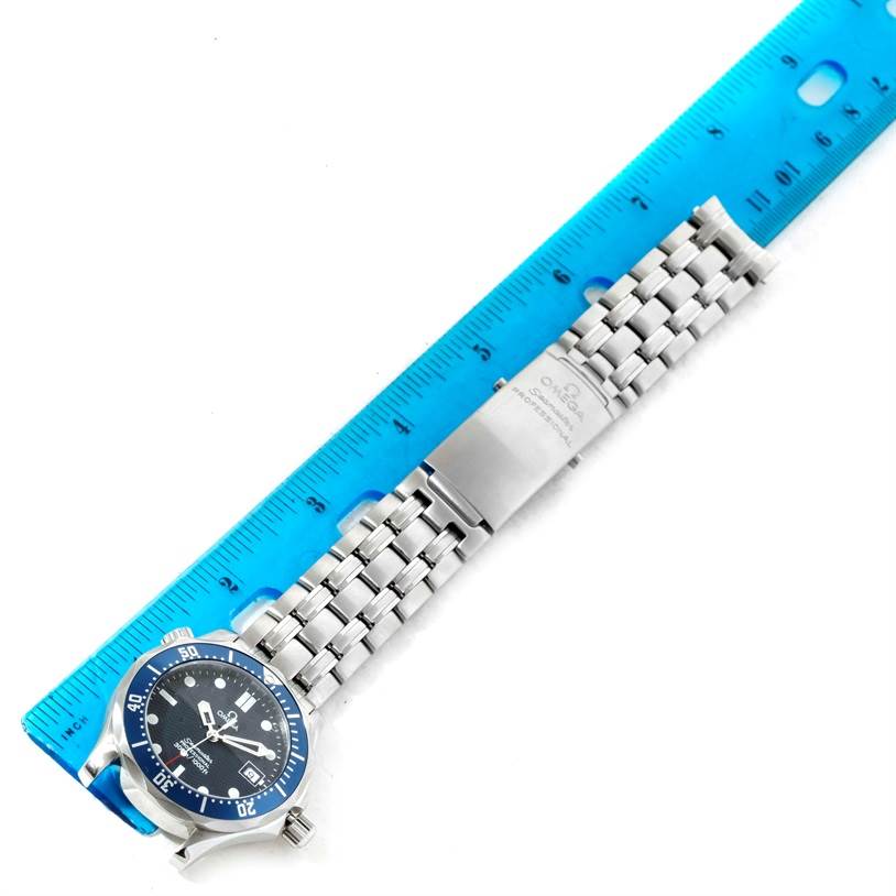 An Omega Seamaster 2561.80.00 Men
s Stainless Steel Blue Dial 2561.80.00 Men
s Stainless Steel Blue Dial watch is shown from an overhead angle, including its face, bracelet, and clasp alongside a blue ruler for scale.