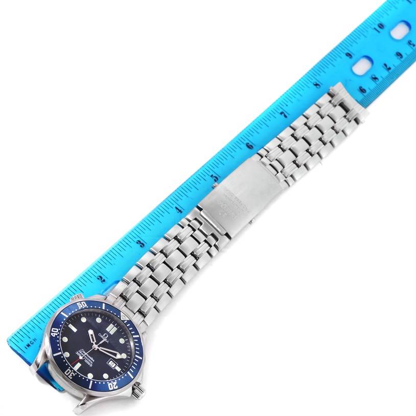 The Omega Seamaster 2541.80.00 Men
s Stainless Steel Blue Dial 2541.80.00 Men
s Stainless Steel Blue Dial watch is shown from above, displaying its face, bezel, and metal bracelet alongside a blue measuring ruler.