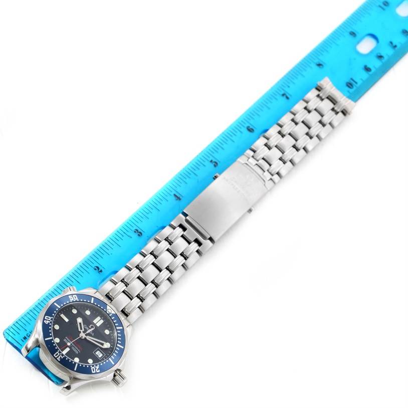 The Omega Seamaster 2223.80.00 Men
s Stainless Steel Blue Dial 2223.80.00 Men
s Stainless Steel Blue Dial watch is shown from a top-down angle, highlighting the face, bezel, and metal bracelet next to a blue ruler.