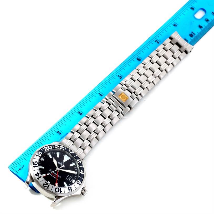 The Omega Seamaster 2534.50.00 Men
s Stainless Steel Black Dial 2534.50.00 Men
s Stainless Steel Black Dial watch is shown from a top angle alongside a blue ruler, highlighting its face and stainless steel bracelet.