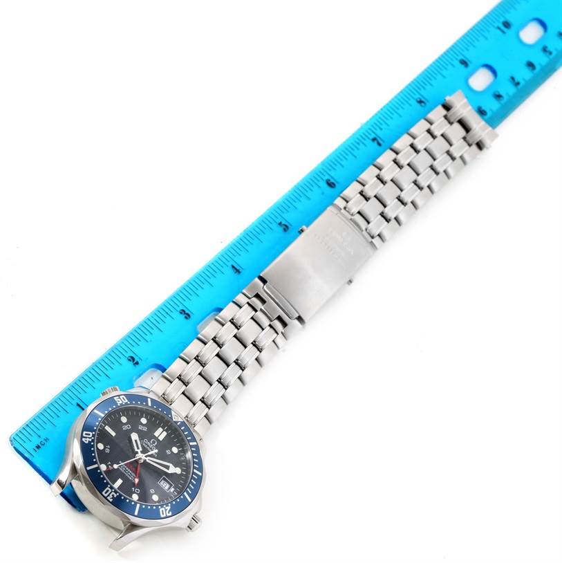 The image shows the Omega Seamaster 2535.80.00 Men
s Stainless Steel Blue Dial 2535.80.00 Men
s Stainless Steel Blue Dial watch with a metal bracelet next to a blue ruler, viewed from the front angle.