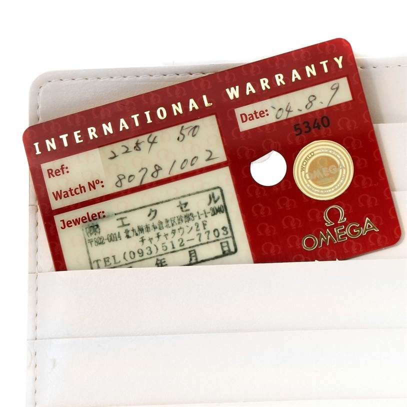 An Omega Seamaster 2254.50.00 Men
s Stainless Steel Black Dial 2254.50.00 Men
s Stainless Steel Black Dial international warranty card is shown, partially inserted in a white case.