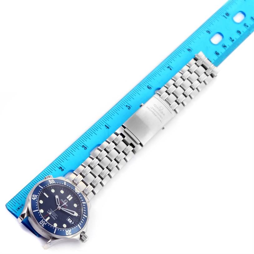 An Omega Seamaster 2220.80.00 Men
s Stainless Steel Blue Dial 2220.80.00 Men
s Stainless Steel Blue Dial watch is shown from an overhead angle, featuring its face, bezel, and metal bracelet alongside a blue ruler.