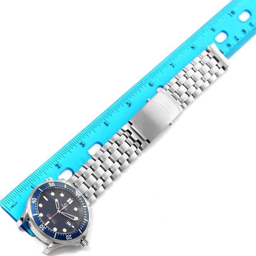 The Omega Seamaster 2221.80.00 Men's Stainless Steel Blue Dial 2221.80.00 Men's Stainless Steel Blue Dial watch is shown flat with the face, bezel, bracelet, and clasp visible, alongside a blue ruler for scale.